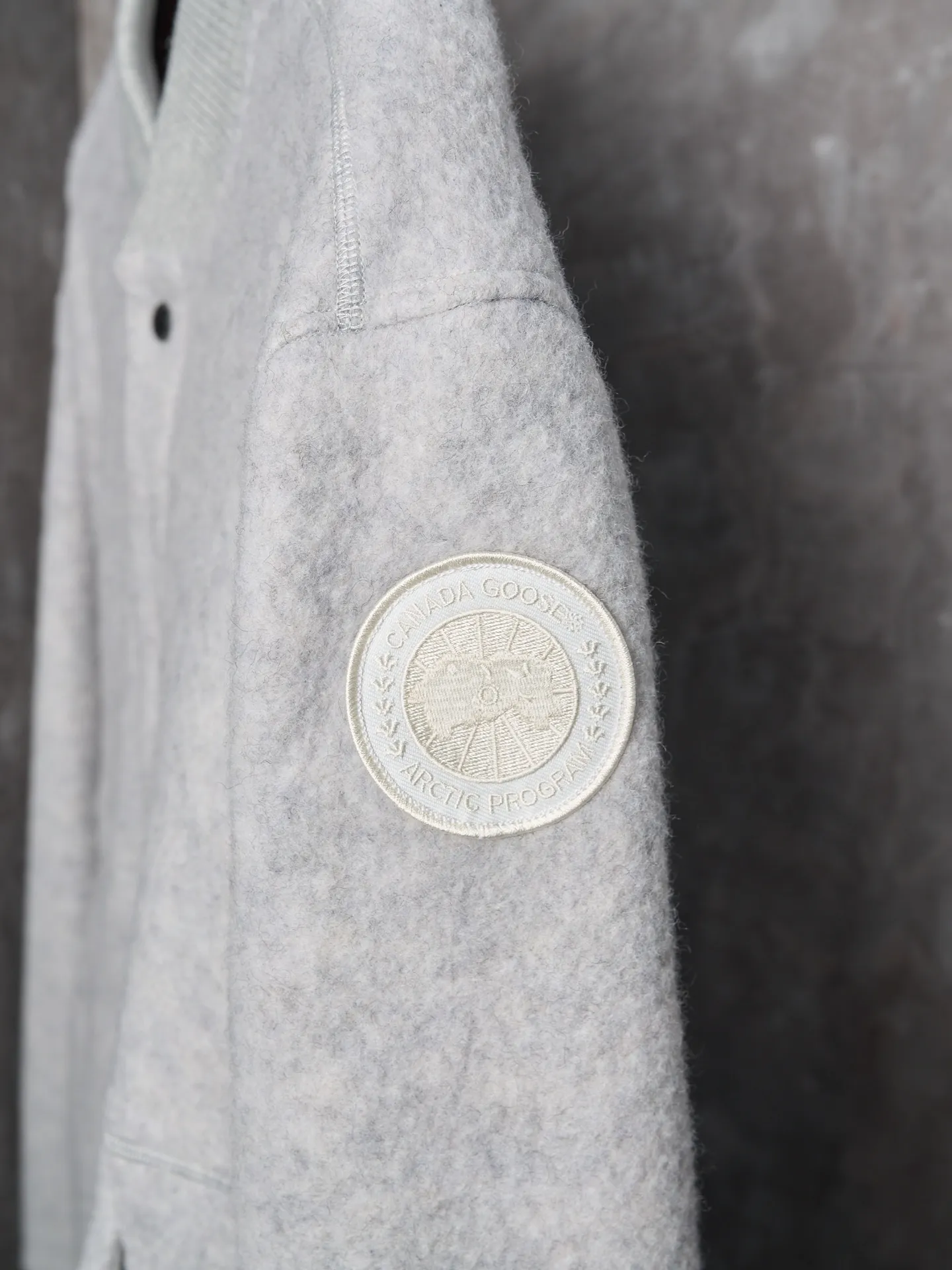 P760 Actual hanging auction] Canada Goose/Canada Goose Fleece Badge Button Cashmere Jacket [Color] Dark Gray Light Gray [Size] S M L XL Wool Blend Fabric: The main fabric of this jacket is light gray wool blend fabric to improve the wear resistance, wrinkle resistance and warmth of the fabric. Wool provides good warmth and a natural feel, while blended fibers enhance the fabric's practicality and durability.  RIBBED KNIT: The collar, cuffs and hem are ribbed knitted for added stretch and fit.  The cutting process needs to ensure that the texture and color of the fabric are evenly distributed, especially with this light gray tone, to avoid chromatic aberrations. The stretchability of wool-blend fabrics needs to be taken into consideration when cutting pieces to ensure dimensional stability of the finished garment.      Use a sewing needle and thread suitable for wool-blend fabrics to avoid damage to the fabric during sewing. The sewing stitches are even and firm to prevent thread stripping.      The temperature needs to be controlled during ironing to avoid high temperature damage to the fabric while keeping the fabric smooth and crisp.   The front and back body parts, sleeves and other main parts are stitched with flat seams to ensure a smooth silhouette.   Align the fabric texture at the splices to keep the look neat.     Details such as pockets and cuffs are designed with inset pockets to increase practicality and aesthetics.     The splicing areas are reinforced to improve durability.  The white circular armband on the left arm is an important part of the brand identity and is finely sewn to ensure it is strong and flat.
